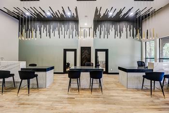 a dining room with a table and chairs and a lobby with large windows at Ventana Oaks Apartments, Austin, Texas